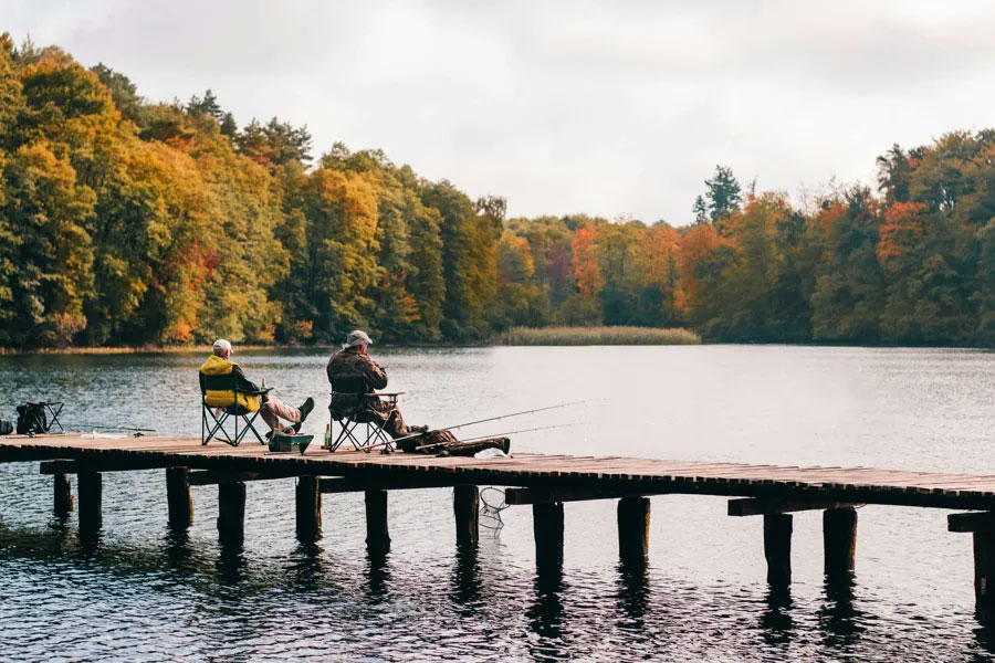 Illustration photo from Pexels.com showing tho elderly men sitting by a lake.